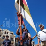 160724fiestacomarcaspendones Un pendonero de Posada y Torre entra en la Plaza Mayor con la enseña y un niño sobre sus hombros.